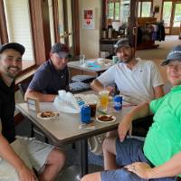 Four alumni sitting at table eating